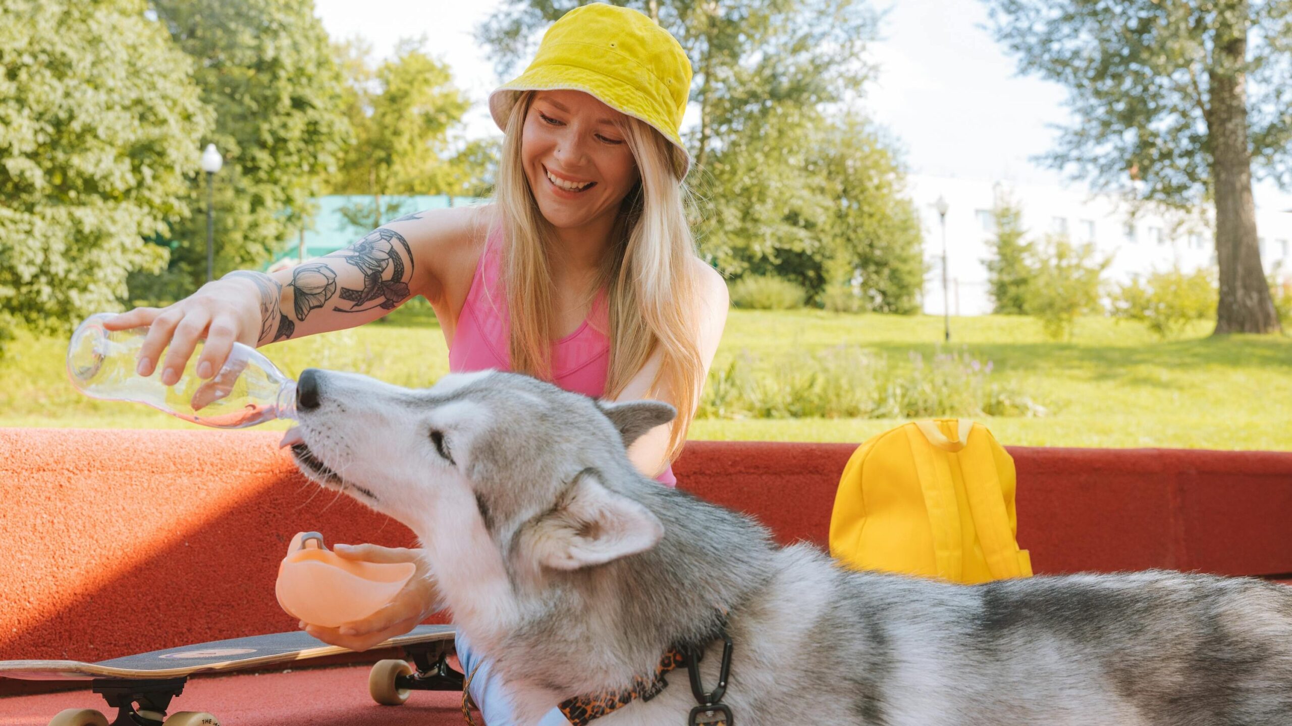Woman in Yellow Knit Cap Sitting Beside Siberian Husky